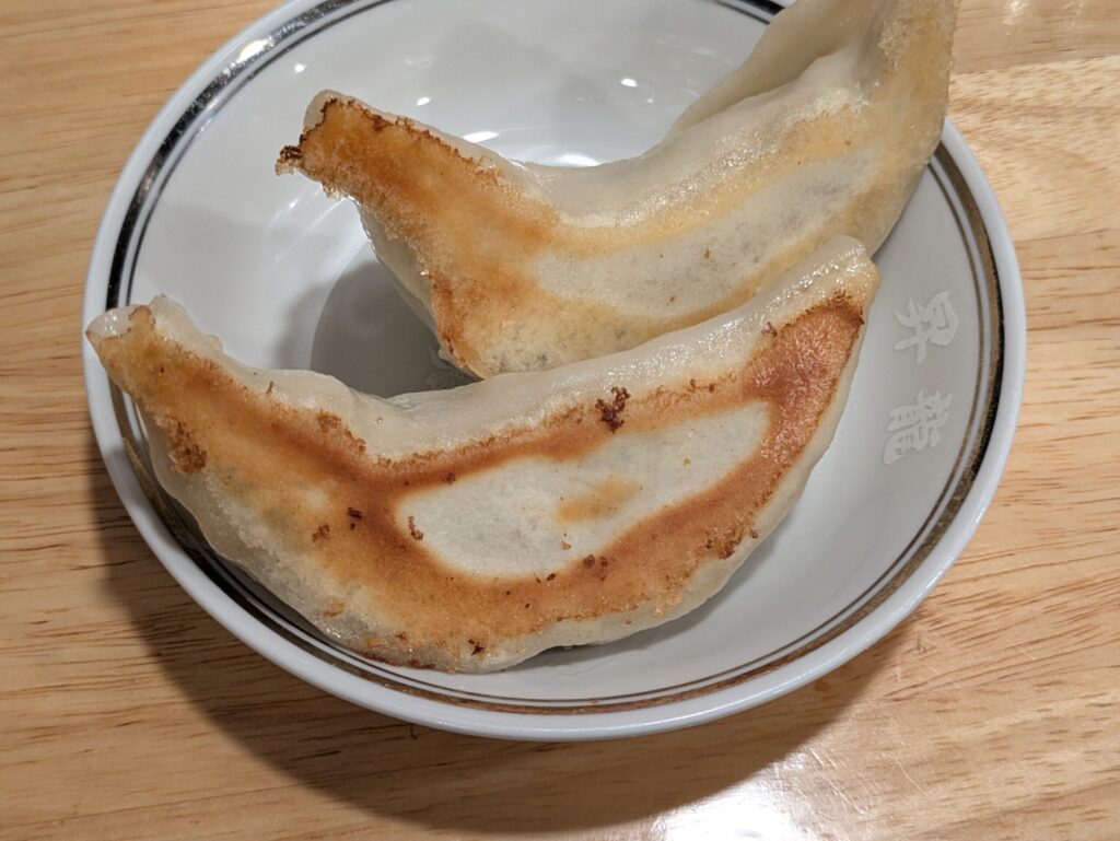 上野・昇龍の半餃子2個。大ぶりの餃子が皿に2個盛られている